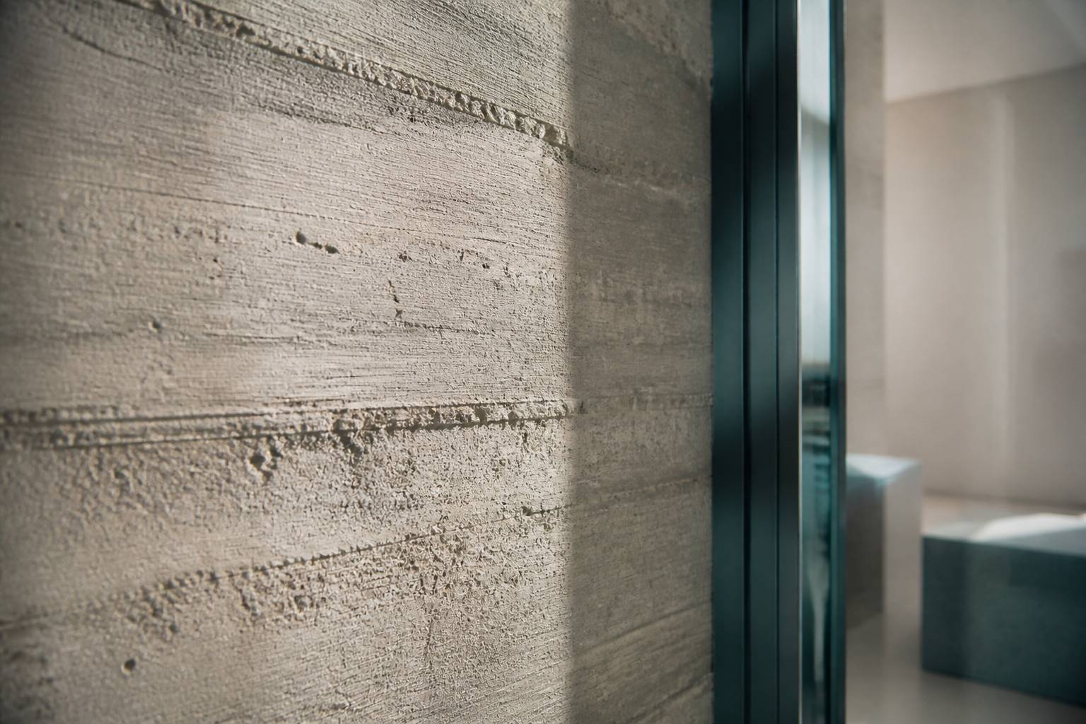 Texture d'un mur en béton brut avec traces de coffrage en lumière rasante
